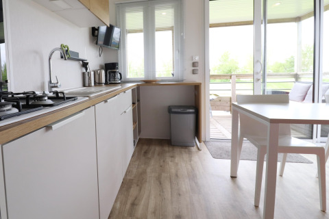 Cucina moderna e zona pranzo in chalet 'Terrace lodge 2' nei Paesi Bassi, vista sulla terrazza.