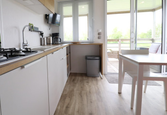 Moderne Küche und Essbereich in einem Chalet namens 'Terrace lodge 2' in den Niederlanden mit Terrasse.