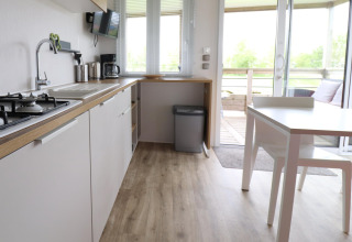 Cucina e zona pranzo moderna nel chalet 'Terrace lodge 2' nei Paesi Bassi, con vista sulla terrazza.