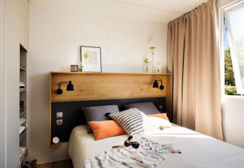 Modernes Schlafzimmer in der Terrace Lodge 2, Niederlande, mit großem Bett und hellem Fenster.
