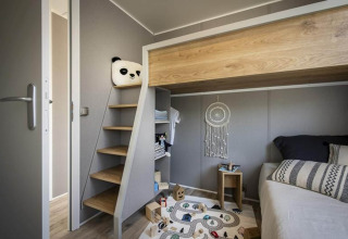 Modern kids’ room at Terrace Lodge 2, Netherlands with loft bed, stairs and cozy play area.