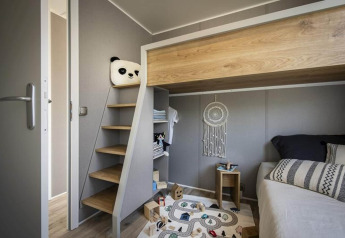 Modernes Kinderzimmer im Terrace Lodge 2, Niederlande, mit Hochbett, Spielteppich und Deko.