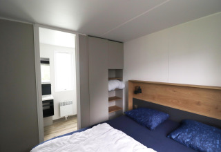 Camera da letto nello chalet Terrace Lodge 2 nei Paesi Bassi con letto matrimoniale, armadi e bagno moderno.