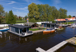 Foto vom Safari-Zelt 'Heeg 4 Personen' am Wasser mit Hausbooten und Segelbooten in den Niederlanden.