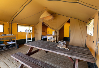 Indvendig billede af en safari telt Safari Tent Heeg for 4 personer, træbord og køkken i Holland.