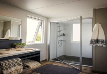 Moderne badkamer in het Terrace lodge 2 chalet in Nederland met glazen douche en grote ramen.