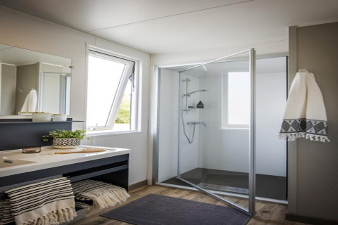 Bagno moderno dello chalet Terrace lodge 2 nei Paesi Bassi con doccia in vetro e ampie finestre luminose.