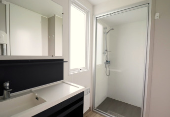 Moderne badkamer met douche, grote spiegel en wastafel in Terrace Lodge 2 chalet in Nederland.