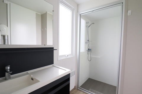 Bagno moderno con doccia, grande specchio e lavabo nel chalet Terrace Lodge 2 nei Paesi Bassi.