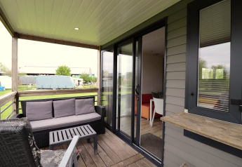 Wooden terrace with outdoor seating at Terrace Lodge 2, overlooking the countryside in the Netherlands.