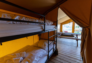 Innenansicht des Safari-Zeltes Heeg für 4 Personen in den Niederlanden mit Etagenbetten und Terrasse.