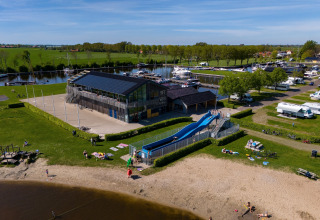 Luftaufnahme eines Safarizeltplatzes in Heeg, Niederlande, mit Wasserrutsche, Strand und Yachthafen.