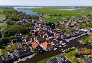 Luftaufnahme von Heeg in den Niederlanden mit Kanälen, Booten und grüner Landschaft im Sommer.