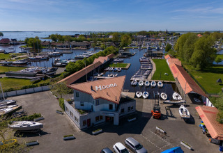 Luftaufnahme eines Yachthafens mit Segelbooten bei Safari Tent Heeg in den Niederlanden an einem sonnigen Tag.