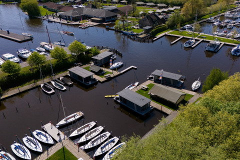 Luftaufnahme vom Safari Zelt Heeg für 4 Personen, umgeben von Wasser, Booten und Natur in den Niederlanden.