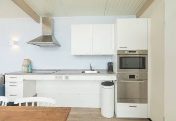 Cocina moderna en la casa de playa Sea Lodges Ameland 4 en Países Bajos, con gabinetes blancos.