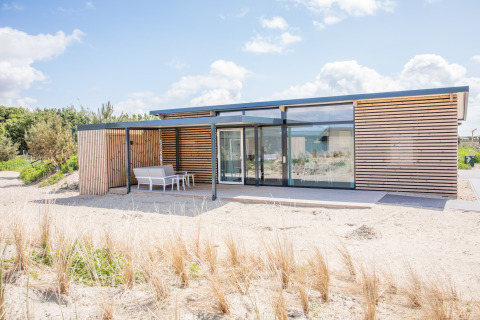 Moderne strandwoning Sea Lodges Ameland 4 in Nederland met hout en grote glaspartijen.