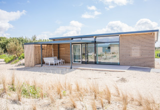 Moderne strandwoning Sea Lodges Ameland 4 in Nederland met hout en grote glaspartijen.