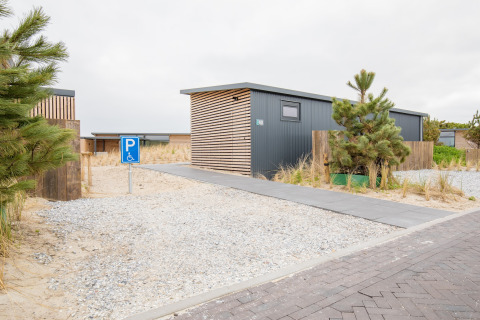 Modern strandhuis bij Sea Lodges Ameland 4 in Nederland met rolstoelvriendelijke parkeerplaats en duinpad.
