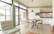 Helles, modernes Wohnzimmer mit offener Küche und Essbereich in Sea Lodges Ameland 3, Niederlande.
