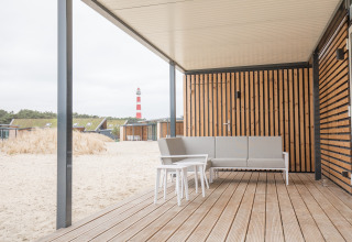 Strandterras met moderne zit en uitzicht op vuurtoren bij Sea Lodges Ameland 3 in Nederland.