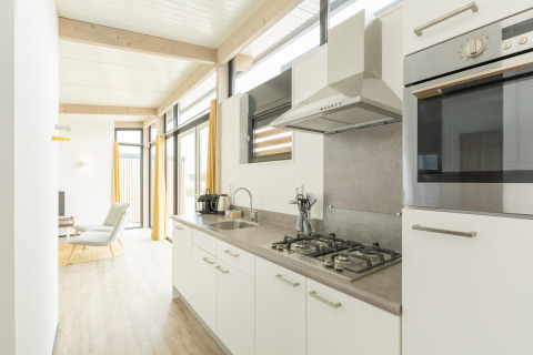 Heldere, moderne keuken in het Sea Lodges Ameland 2 strandhuis in Nederland met grote ramen.