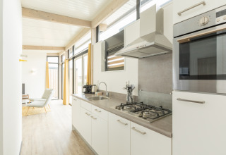 Heldere, moderne keuken in het Sea Lodges Ameland 2 strandhuis in Nederland met grote ramen.