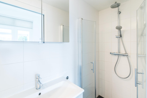 Modernes, helles Bad mit Dusche und Waschbecken im Ferienpark „Boomhiemke 7“ in den Niederlanden.
