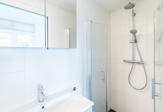 Baño moderno y luminoso con ducha y lavabo en Holiday park «Boomhiemke 7» en los Países Bajos.