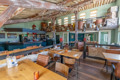 Interior acogedor de restaurante en Holiday park Boomhiemke 7 en Países Bajos, con decoración rústica y bar.