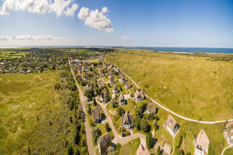 Panoramic view of holiday cottages at Boomhiemke 7 park on green landscape near the sea, Netherlands.