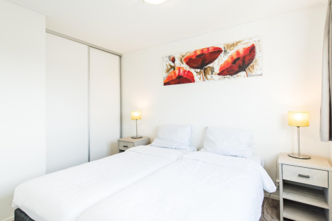 Lyst og moderne soveværelse i Holiday park «Boomhiemke 6», Nederlandene, med dobbeltseng og kunst.