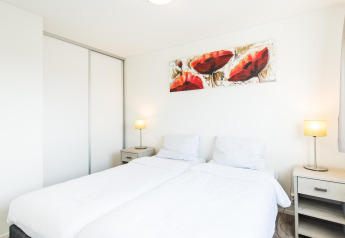 Lyst og moderne soveværelse i Holiday park «Boomhiemke 6», Nederlandene, med dobbeltseng og kunst.