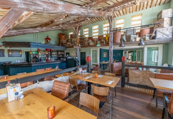 Vista interior de un restaurante rústico con muebles de madera en Holiday park Boomhiemke 6 en los Países Bajos.