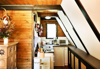 Cuisine en bois chaleureuse à la Ferienhütte Trabochersee en Autriche, avec four, micro-ondes et accessoires.