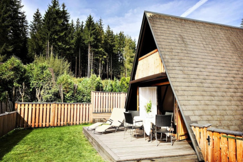 A-formet træhytte med terrasse og havemøbler ved skov, Ferienhütte Trabochersee, Østrig.