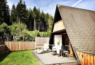 A-formet træhytte med terrasse og havemøbler ved skov, Ferienhütte Trabochersee, Østrig.