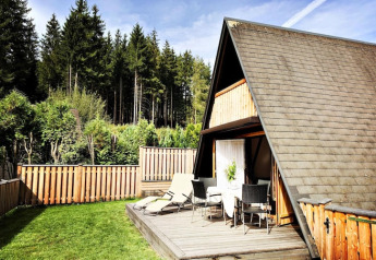 A-vormig houten huisje met terras en tuinset bij Ferienhütte Trabochersee in Oostenrijk.