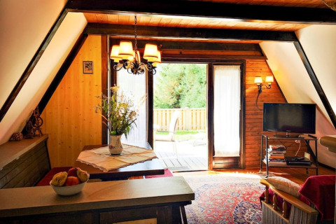 Hyggelig stue i Ferienhütte Trabochersee i Østrig med træinteriør, tv og udsigt til terrasse.