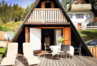 Hyggelig A-formet feriehytte ved Trabochersee i Østrig med terrasse, liggestole og udsigt til natur.