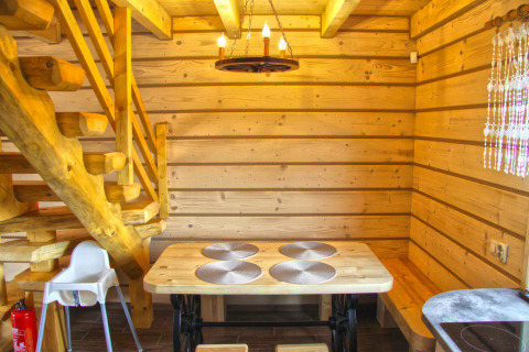 Intérieur en bois d’un chalet avec table à manger, escalier et lampe au Holiday home «Maryna» en Allemagne.
