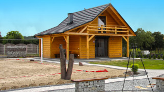 Holiday home Maryna: Chalet de madera con balcón, cancha de arena y zona de fogata en un entorno ajardinado.