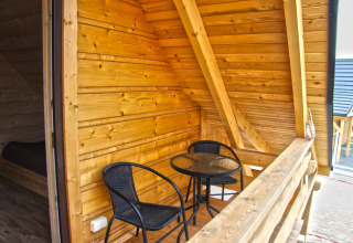 Balcon en bois avec deux chaises noires et une table ronde au chalet Holiday home «Maryna» en Allemagne.