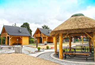 Chalets en bois et tonnelle au toit de chaume à Holiday home «Maryna» en Allemagne, lieu parfait pour se détendre.