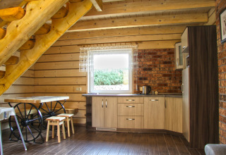 Intérieur de la maison de vacances Maryna en Allemagne avec escalier en bois, cuisine et table à roues.