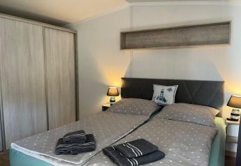 Slaapkamer met tweepersoonsbed, stippenbeddengoed en nachtkastjes in Holiday home ‘Inselblick’.