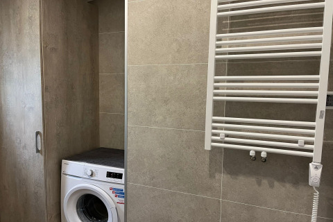 Lavadora y radiador toallero en un baño moderno de la casa de vacaciones Inselblick en Nowe Warpno, Alemania.