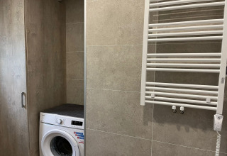 Washing machine and towel radiator in a modern bathroom at Holiday Home Inselblick in Nowe Warpno, Germany.