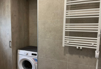Lavadora y radiador toallero en un baño moderno de la casa de vacaciones Inselblick en Nowe Warpno, Alemania.