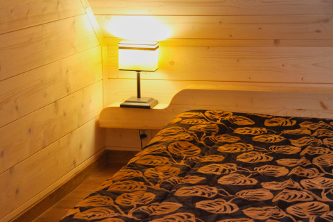 Camera accogliente in legno con letto e lampada da comodino, Holiday home «Maryna» in Germania
